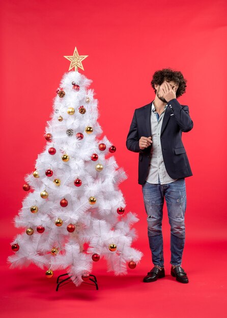 Ein Mann steht neben dem Weihnachtsbaum