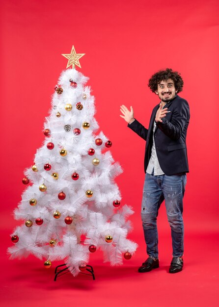 Ein Mann steht neben dem Weihnachtsbaum