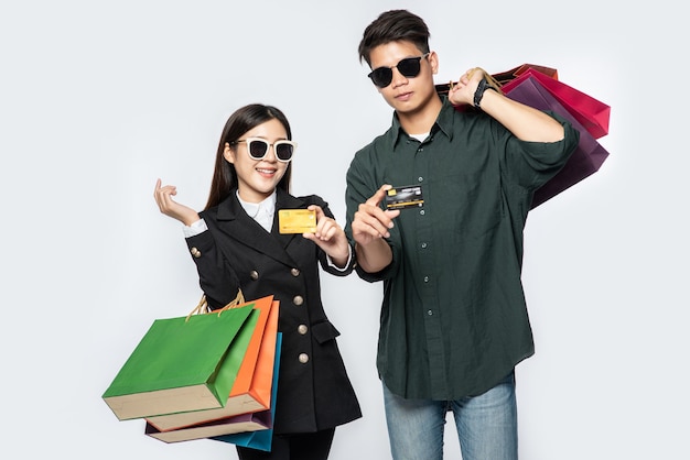 Ein Mann und eine Frau trugen eine Brille und trugen viele Papiertüten zum Einkaufen