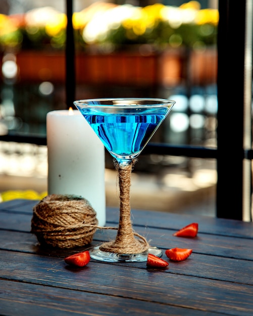 Ein Martini-Glas der blauen Lagune, verziert mit Jute