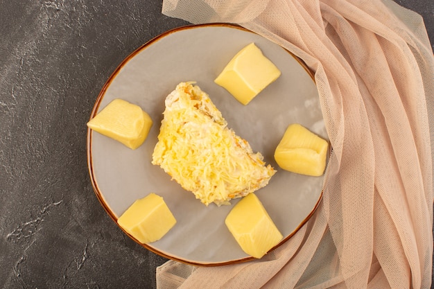 Kostenloses Foto ein mayyonaised gemüsesalat von oben mit hühnchen im inneren und frischkäse im teller auf dem grauen schreibtischsalat