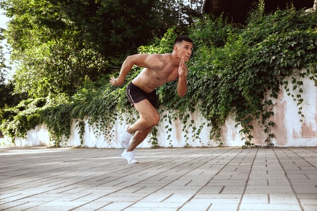 Ein muskulöser männlicher Athlet, der Training im Park tut