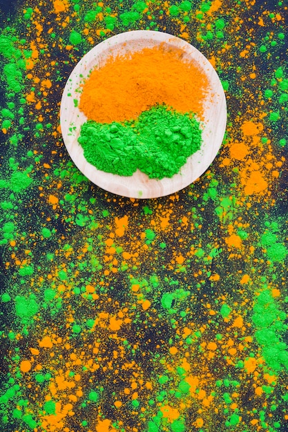 Ein orange und grünes Pulver auf hölzerner Platte mit Splatterhintergrund