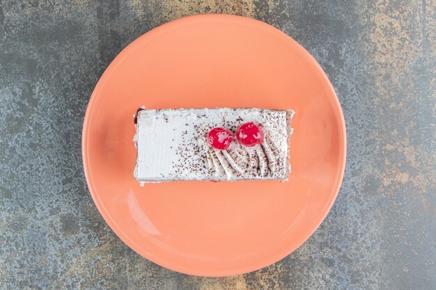 Ein orangefarbener Teller mit köstlichem Kuchen mit Beeren