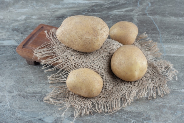 Ein paar Kartoffeln auf dem Untersetzer, an Bord auf dem Marmortisch.