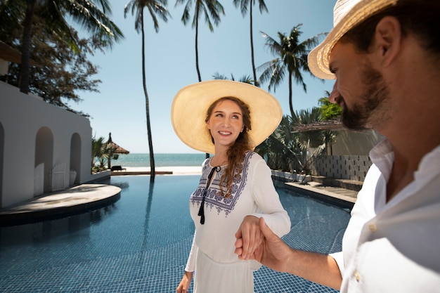 Ein Paar macht im Urlaub einen Spaziergang am Pool