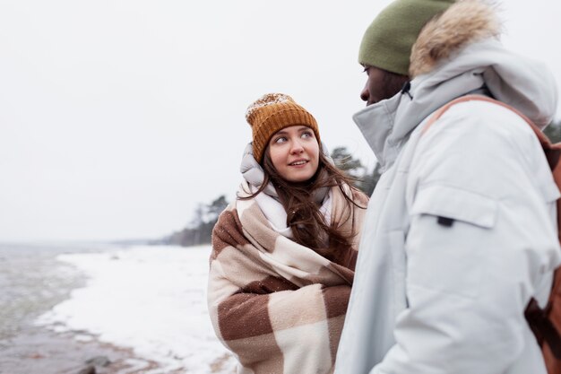 Ein Paar wacht während eines Winter-Roadtrips zusammen am Strand auf