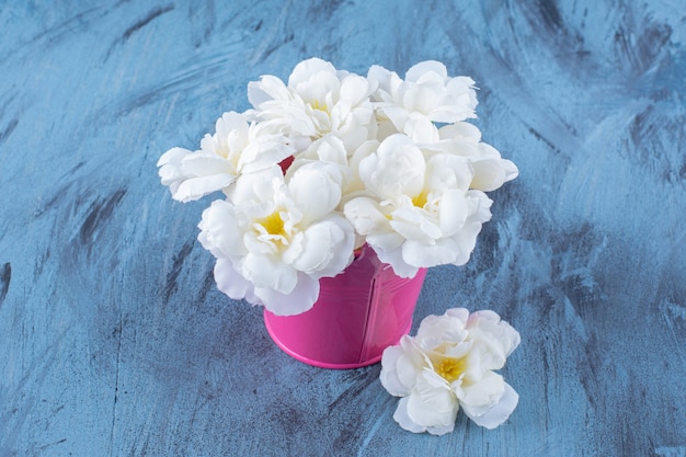 Ein rosa eimer mit schönem weißen blumenstrauß.