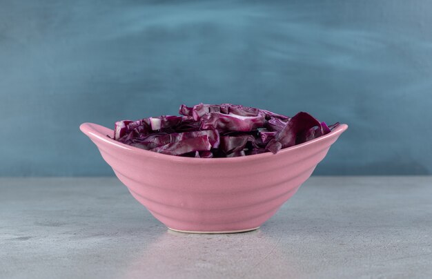 Ein rosa Teller mit geschnittenem Purpurkohlgemüse. Foto in hoher Qualität
