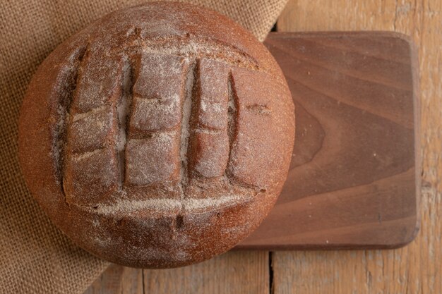 Ein rundes französisches Roggenbrot auf einem hölzernen Brett.