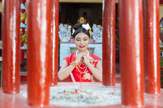 Ein schönes asiatisches Mädchen, das eine rote Anbetung trägt