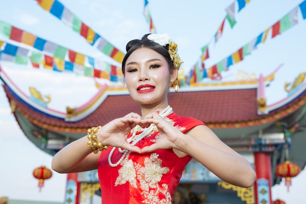Ein schönes asiatisches Mädchen, das eine rote Anbetung trägt