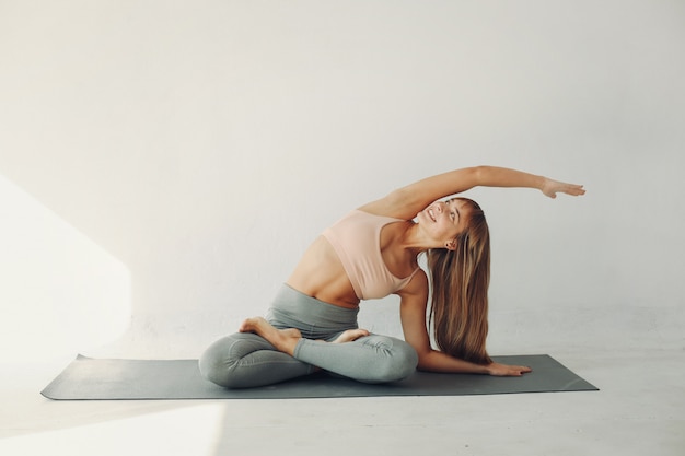Ein schönes Mädchen nimmt an einem Yogastudio teil
