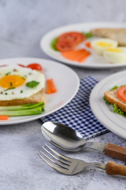 Ein Spiegelei, das auf einem Toast liegt, gekrönt mit Pfeffersamen mit Karotten, Babymais und Frühlingszwiebeln.