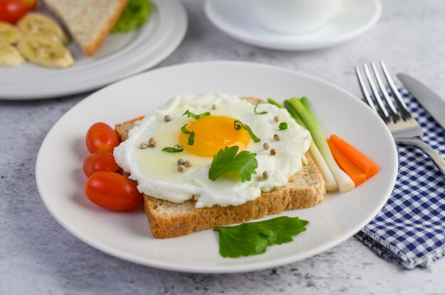 Ein Spiegelei, das auf einem Toast liegt und mit Pfeffersamen mit Karotten und Frühlingszwiebeln belegt ist.