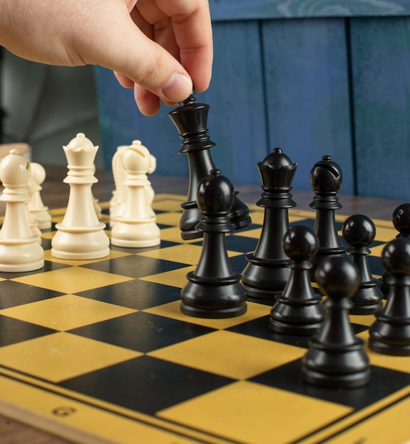 Ein Spieler, der schwarzen König auf Schachbrett spielt
