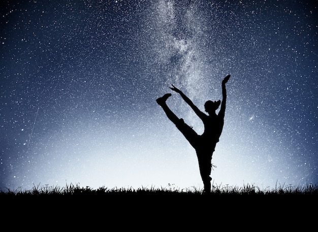 Kostenloses Foto ein sportmädchen im morgengrauen beschäftigt sich mit yoga. fitnesskurse am sternenhimmel