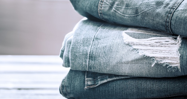 Ein Stapel Jeans auf einem hölzernen Hintergrund