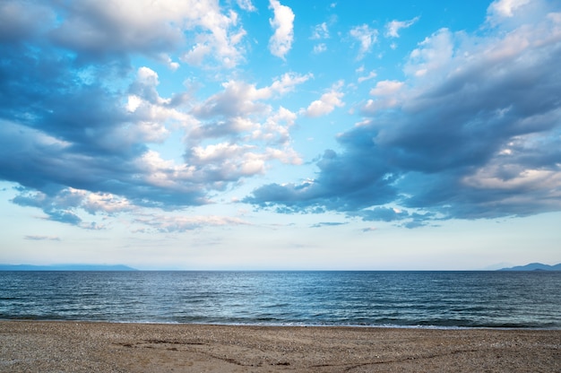 Ein Strand und Ägäisches Meer, teilweise bewölkter Himmel, Griechenland