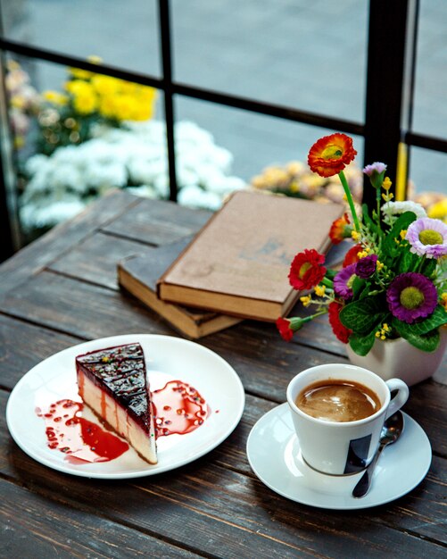 Ein Stück Himbeerkäsekuchen mit Espresso