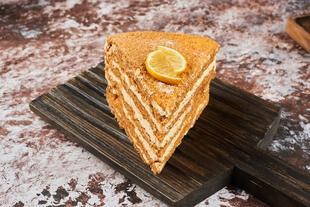 Ein Stück Honigkuchen auf einer Holzplatte.