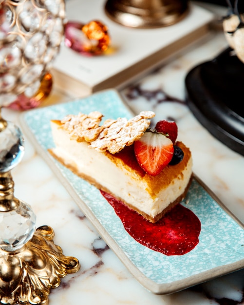 Ein Stück Käsekuchen mit Erdbeere darüber