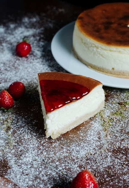 Kostenloses Foto ein stück käsekuchen mit karamell-erdbeersirup auf der oberseite.