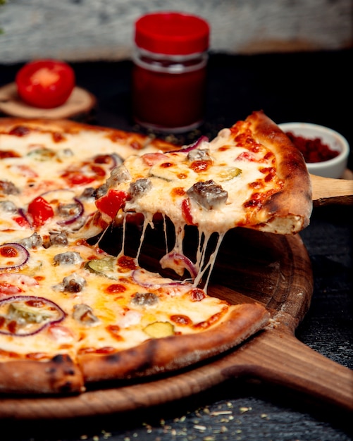 Ein Stück knusprige Pizza mit Fleisch und Käse