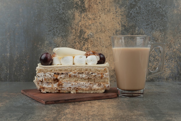 Ein Stück Kuchen mit heißer Tasse Kaffee auf Marmorwand