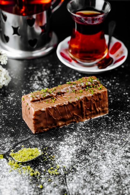 Kostenloses Foto ein stück no-bake-schokoladen-käsekuchen und ein glas tee.