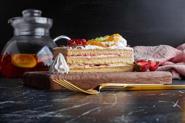 Ein Stück Obstkuchen auf der Holzplatte.