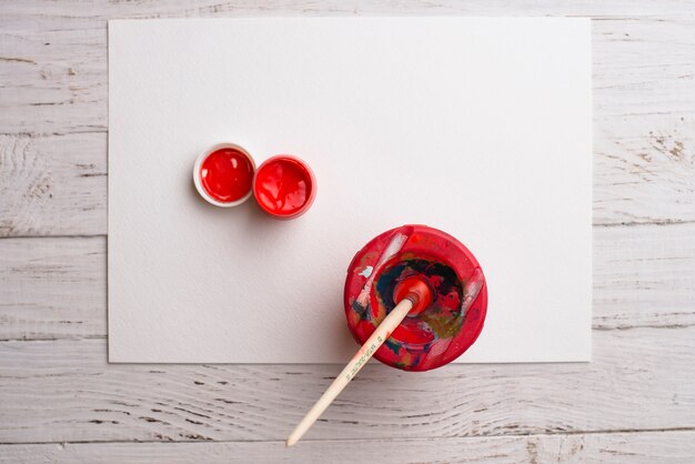 Ein Stück Papier mit roter Farbe und Pinsel