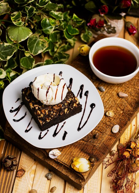 Ein Stück Schokoladen-Brownie mit Walnuss-Vanille-Eis.