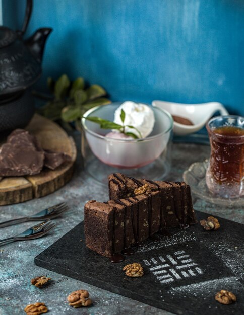 Ein Stück Schokoladen-Brownie-Torte mit einem Glas Tee