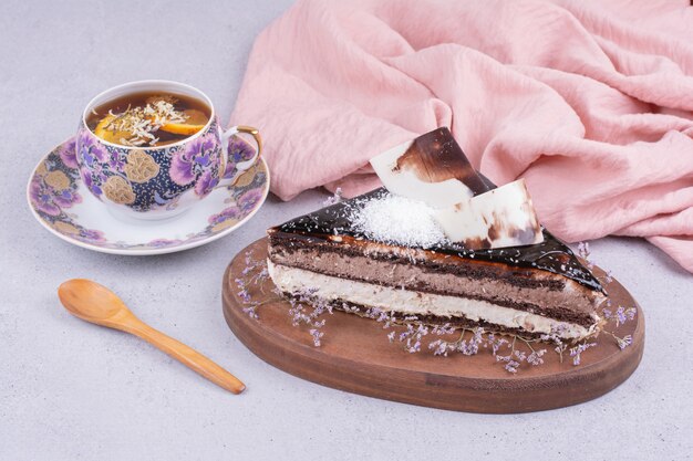 Ein Stück Schokoladen-Ganache-Kuchen mit einer Tasse Kräutertee.
