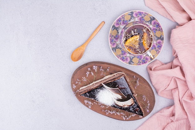 Ein Stück Schokoladen-Ganache-Kuchen mit einer Tasse Kräutertee.