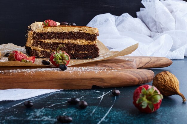 Ein Stück Schokoladenkuchen auf einem Holzbrett.