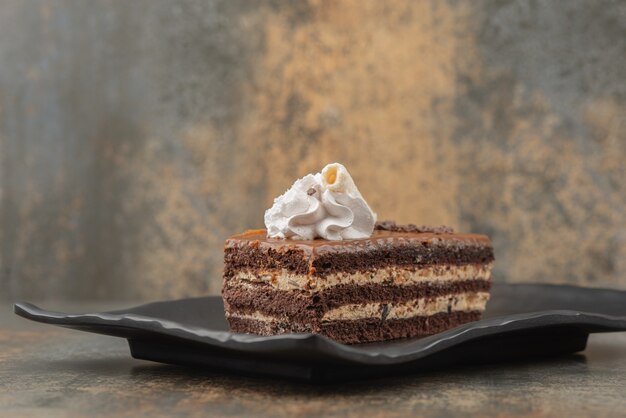 Ein Stück süßer Kuchen auf dunklem Teller