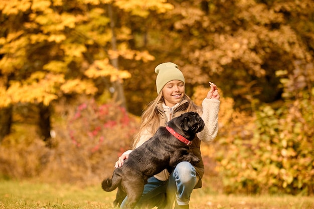 Ein süßes Mädchen füttert ihren Hund im Park