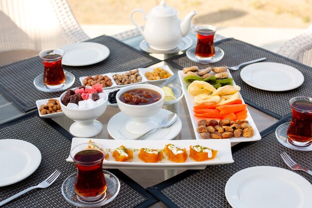 Ein Tee-Zeitplan der Vorderansicht mit Marmeladen-Marmeladen-Nuss-Süßigkeiten und Süßigkeiten im Restaurant während des Tages-Teetischs süß draußen