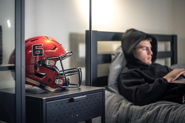 Kostenloses Foto ein teenager sitzt in einem zimmer auf einem bett und benutzt einen laptop