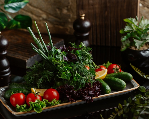 Kostenloses Foto ein teller mit frischem gemüse der saison, darunter tomaten, gurken und viel grün