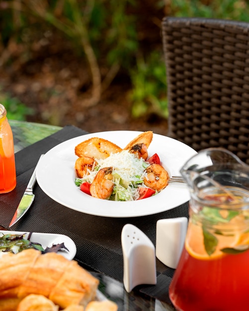 Ein Teller mit Garnelen-Caesar-Salat auf der Restaurantterrasse