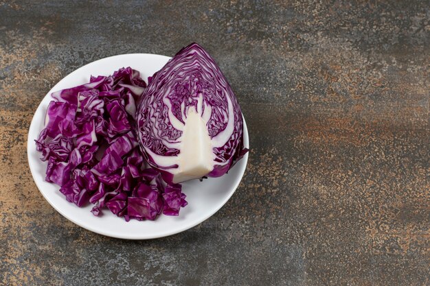 Ein Teller mit geschnittenem Rotkohl auf dem Teller auf der Marmoroberfläche