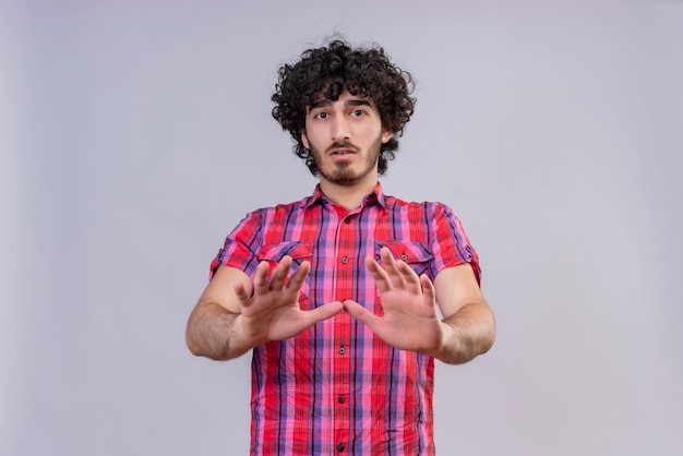 Ein trauriger Mann mit lockigem Haar im karierten Hemd, der versucht, etwas aufzuhalten