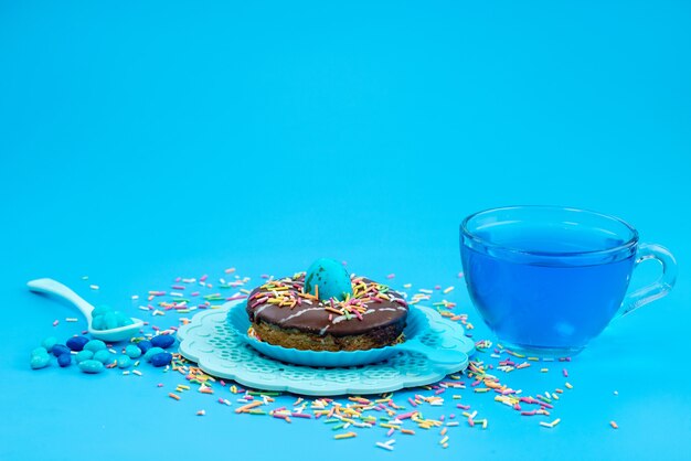 Ein Vorderansicht-Schokoladenkrapfen zusammen mit blauem, Getränk auf blauem, süßem Zucker