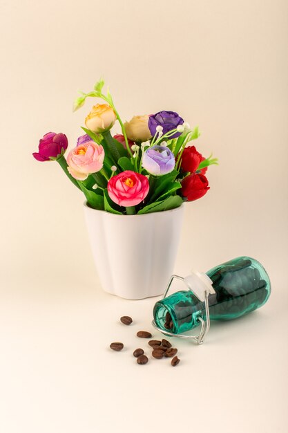 Ein Vorderansichtglas mit Kaffee und Blumen auf dem rosa Tischkaffeefarbblumenkern