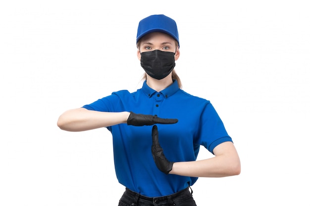 Ein weiblicher Kurier der Vorderansicht in den schwarzen schwarzen Handschuhen der blauen Uniform und der schwarzen Maske, die Zeichen zeigt