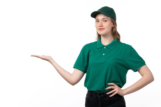 Ein weiblicher Kurier der Vorderansicht in der grünen Uniform, die mit erhabener Hand lächelt