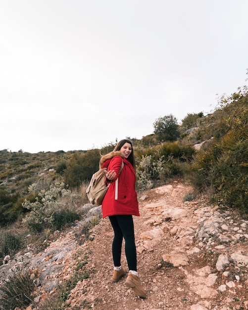 Ein weiblicher Wanderer mit ihrem Rucksack gehend auf Gebirgspfad